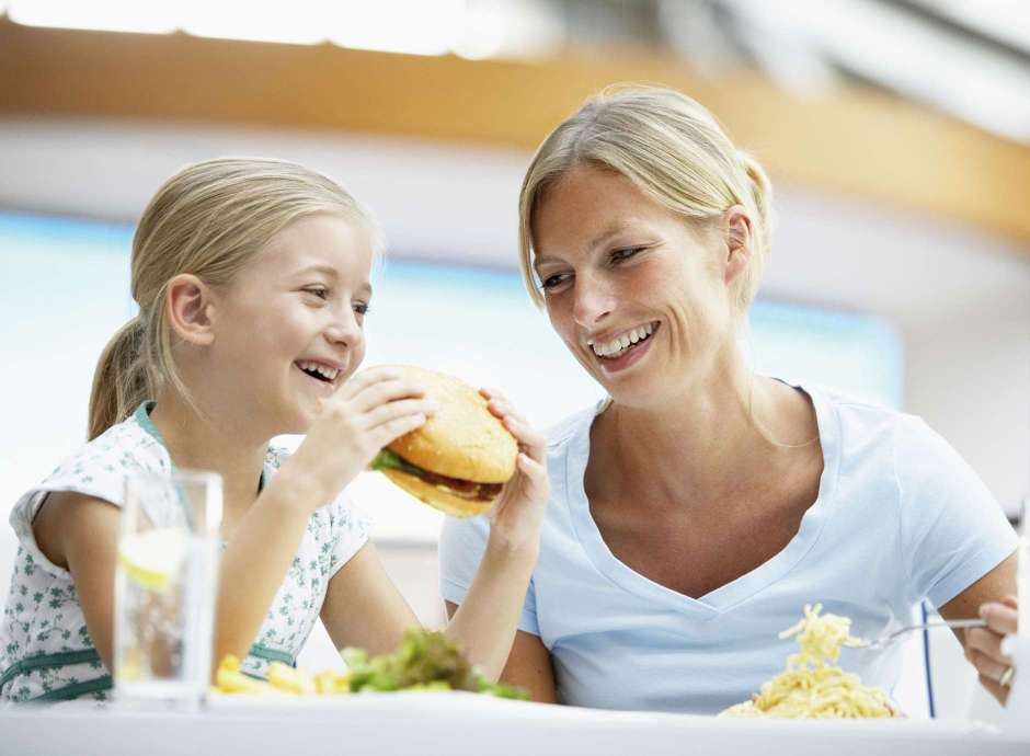 Mother with daughter eating a burger 