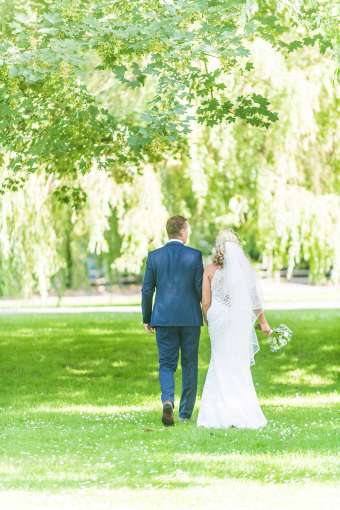 Bride and groom walking in green hotel grounds