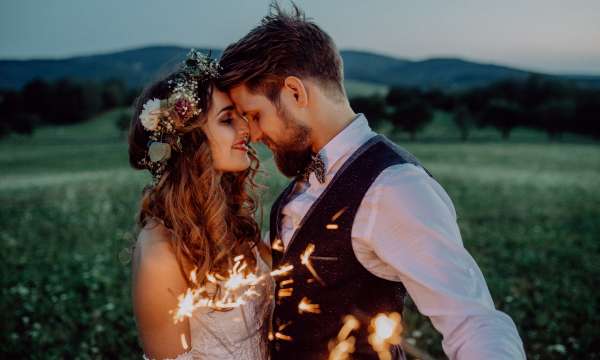 bride and groom in the countryside at dusk with sparkles