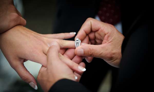 groom putting a wedding ring on a brides finger