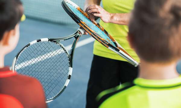 2 boys and a man with tennis rackets