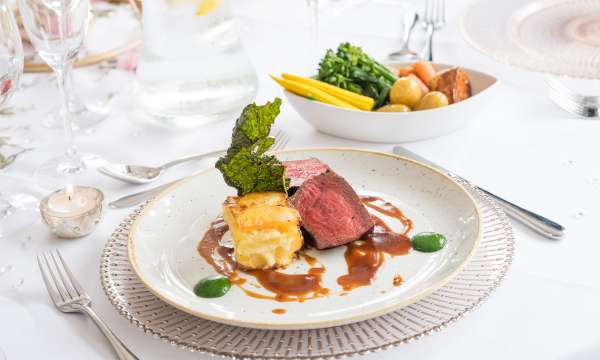 Westcountry Rum of Beef, Vegetables and Candle on Table 