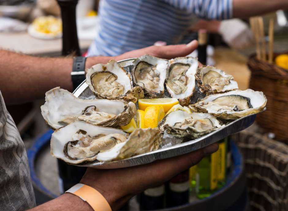 man holding plate of oysters