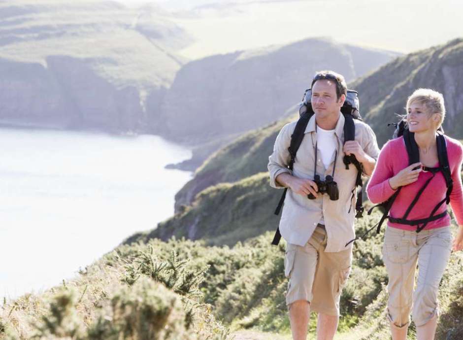 man and woman walking along coastal path