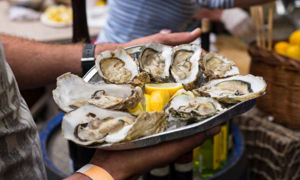 man holding plate of oysters