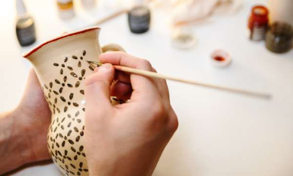 someone painting pottery