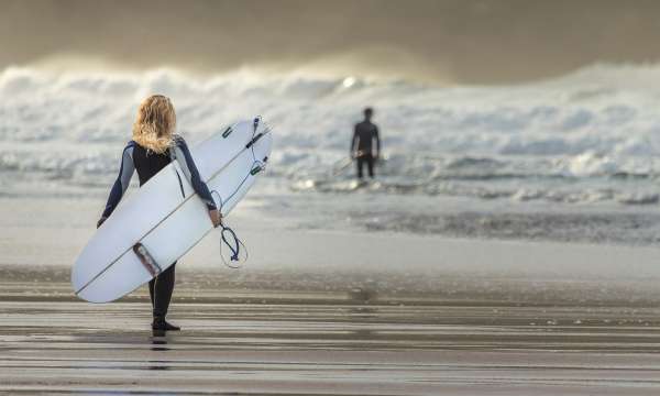 woman surfer walking into sea