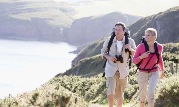 man and woman walking along coastal path